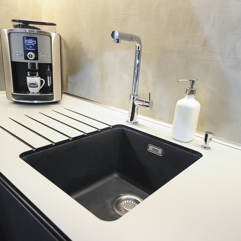 kuchyně s kompaktní deskou a černým dřezem